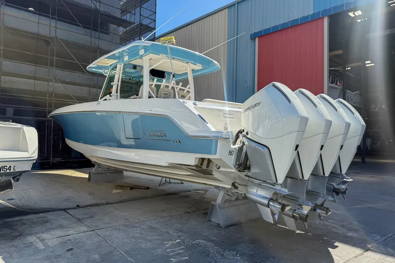 Slide: The Image of 2022 Boston Whaler 380 Outrage boat with four Mercury engines in a marina setting. - 39