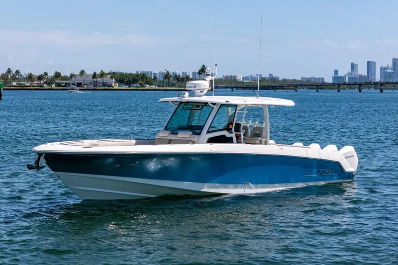 Slide: The Image of 2022 Boston Whaler 380 Outrage boat on calm water with city skyline background. - 4