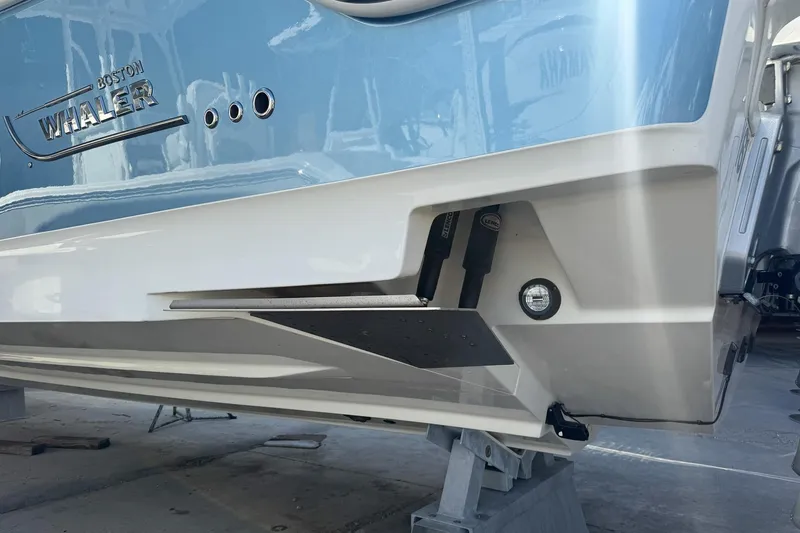 Slide: The Image of 2022 Boston Whaler 380 Outrage boat hull in light blue and white, docked. - 40