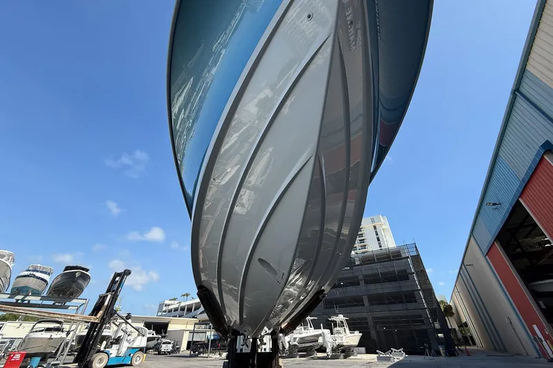 Slide: The Image of 2022 Boston Whaler 380 Outrage boat hull, viewed from below, in a marina setting. - 47