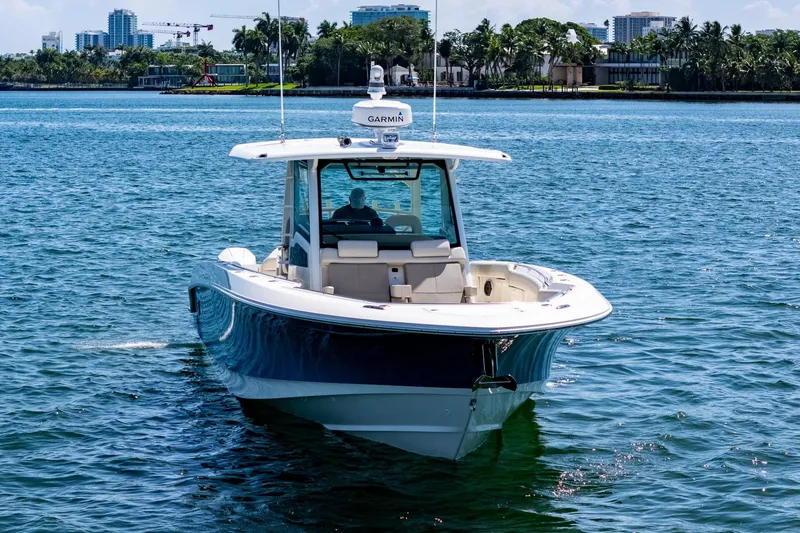 Slide: The Image of 2022 Boston Whaler 380 Outrage boat on water, with cityscape background. - 5
