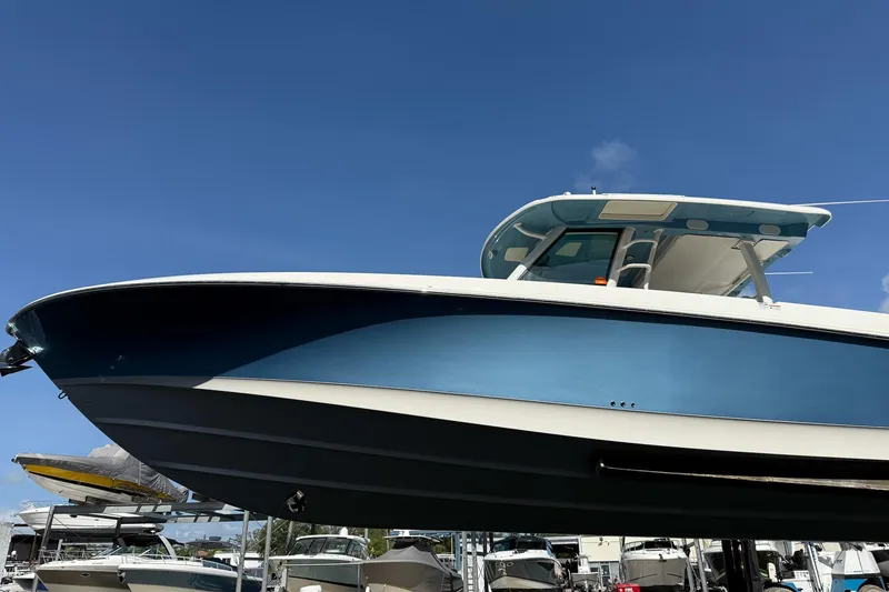 Slide: The Image of 2022 Boston Whaler 380 Outrage boat displayed against a clear blue sky. - 50