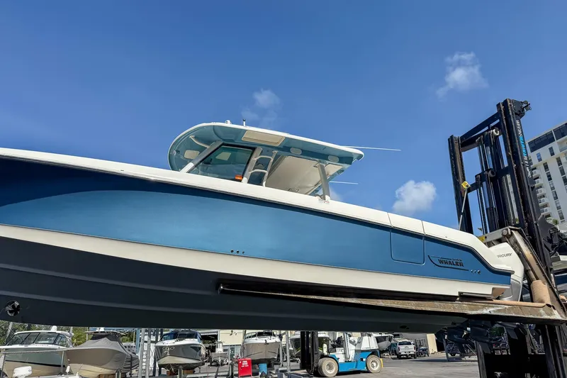Slide: The Image of 2022 Boston Whaler 380 Outrage boat on forklift under clear blue sky. - 51