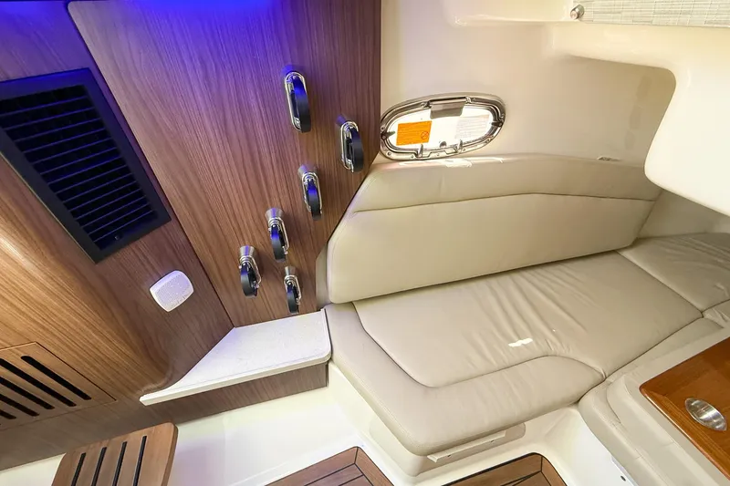 Slide: The Image of 2022 Boston Whaler 380 Outrage cabin interior with wood accents and cushioned seating. - 54