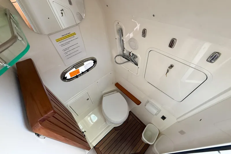Slide: The Image of Boston Whaler 380 Outrage 2022 boat bathroom with modern fixtures and wooden accents. - 56