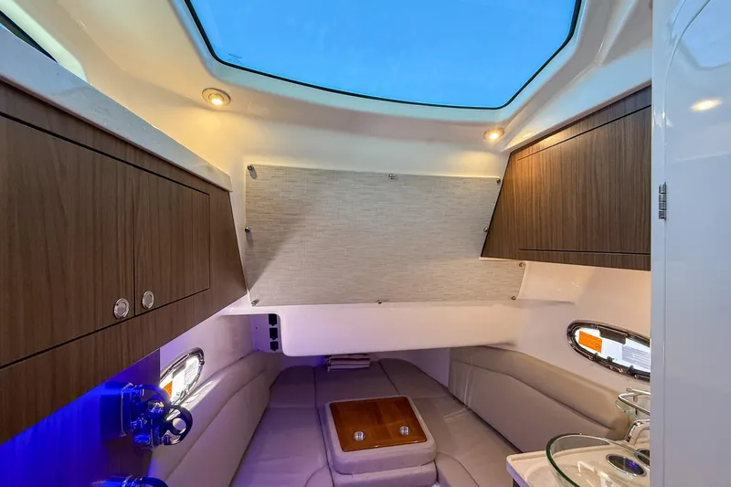 Slide: The Image of 2022 Boston Whaler 380 Outrage cabin interior with skylight, wood cabinets, and seating area. - 67