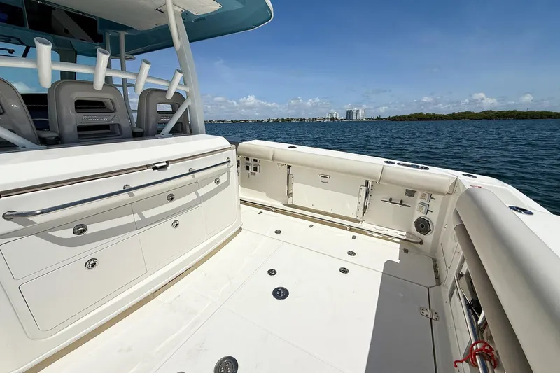 Slide: The Image of 2022 Boston Whaler 380 Outrage boat deck with seating, storage, and ocean view. - 72