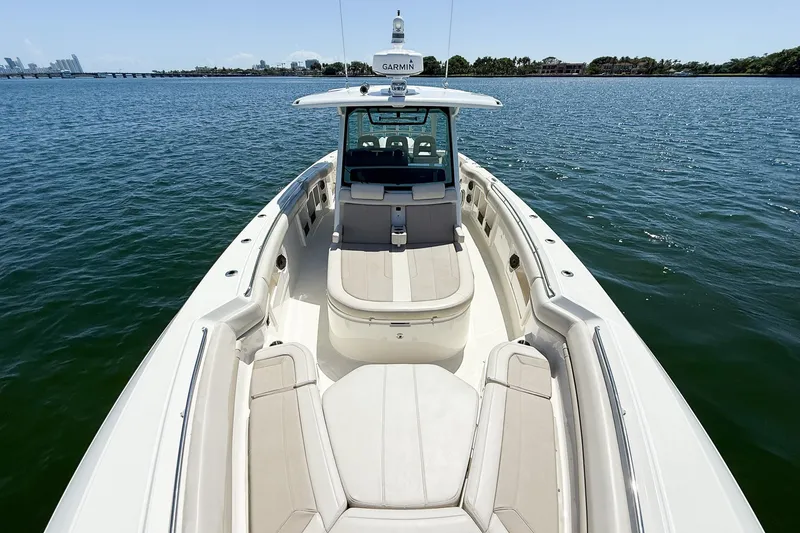 Slide: The Image of 2022 Boston Whaler 380 Outrage boat on calm water, showcasing spacious deck and seating. - 79