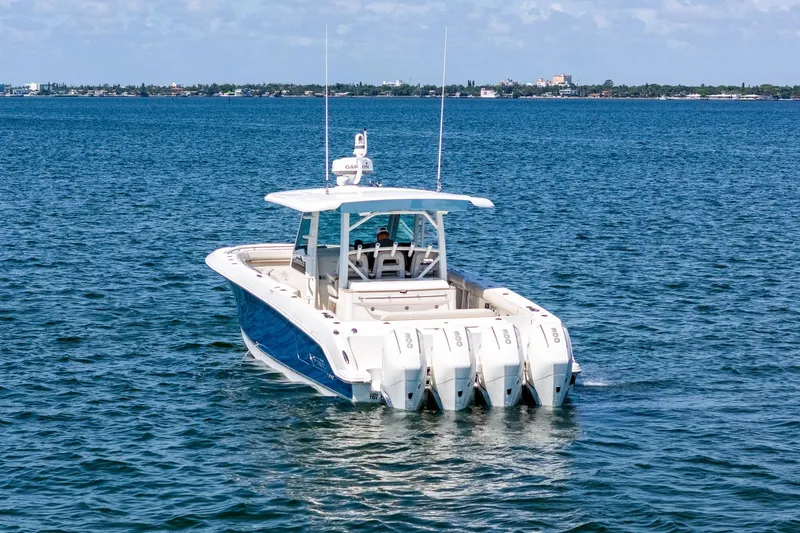 Slide: The Image of 2022 Boston Whaler 380 Outrage boat on open water, featuring four powerful engines. - 8