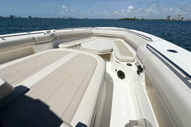 Slide: The Image of 2022 Boston Whaler 380 Outrage boat interior with cushioned seating on open water. - 82