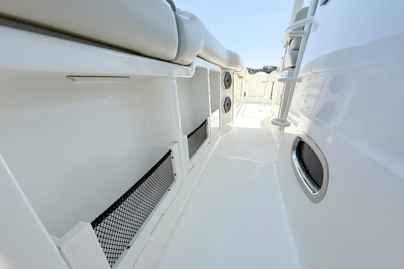 Slide: The Image of 2022 Boston Whaler 380 Outrage interior, featuring sleek white design and storage compartments. - 84
