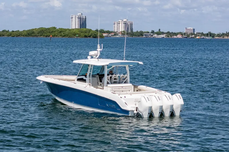 Slide: The Image of 2022 Boston Whaler 380 Outrage boat on calm water with cityscape background. - 9