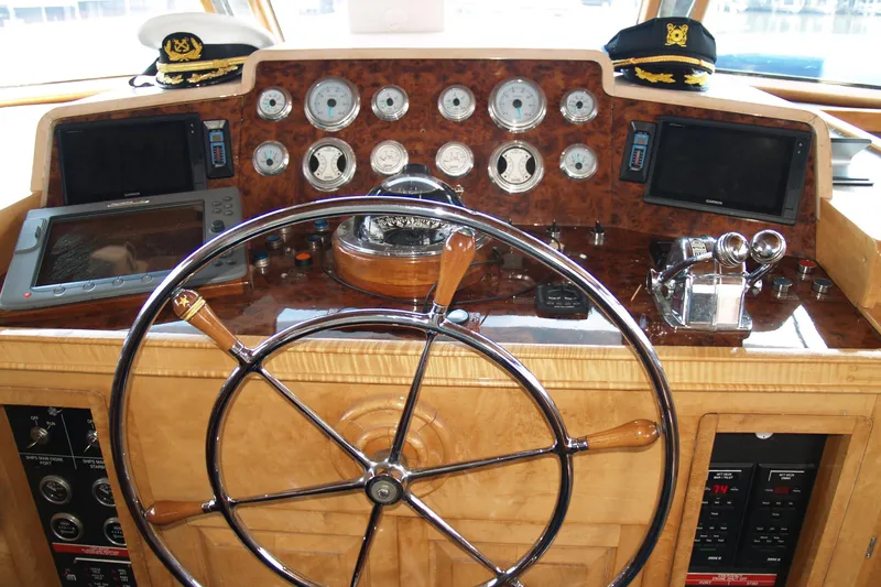 Slide: The Image of 1964 Striker Cockpit interior with wooden flooring, bar stools, and marina view. - 11