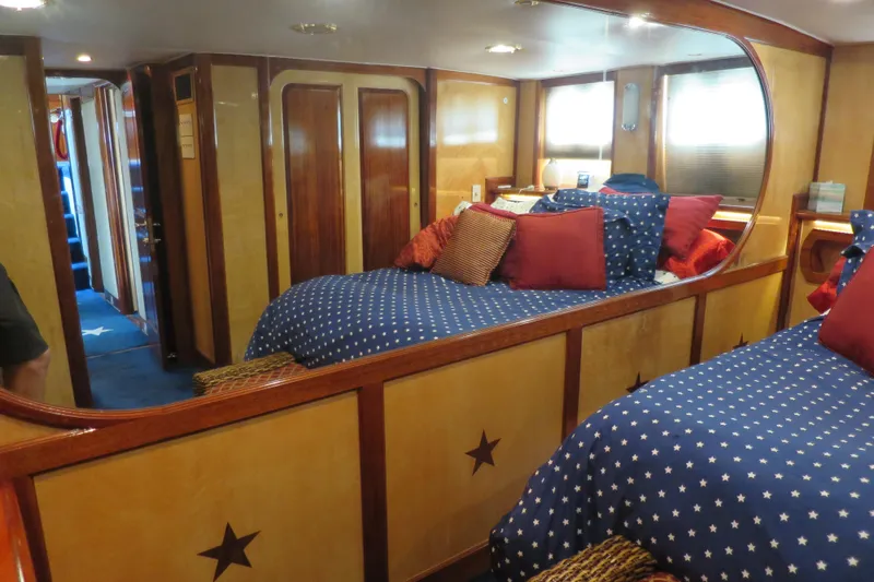 Slide: The Image of Luxurious 1964 Striker Cockpit yacht interior with star-patterned bedding and elegant wood finishes. - 31