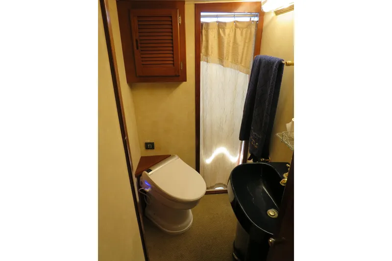 Slide: The Image of Compact bathroom in 1964 Striker Cockpit boat with shower, sink, and toilet. - 33