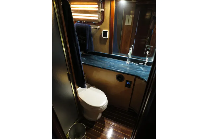 Slide: The Image of Compact bathroom in 1964 Striker Cockpit boat with modern toilet and black sink. - 34