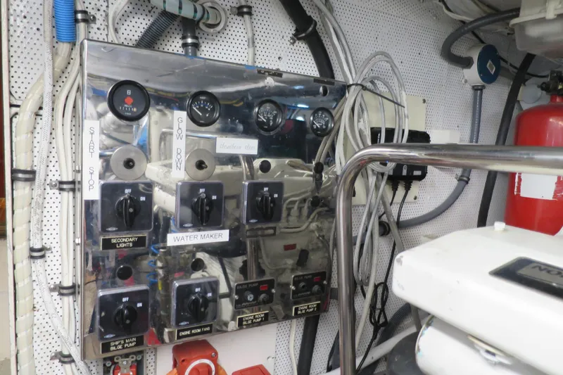 Slide: The Image of Engine room of a 1964 Striker Cockpit boat, featuring a white engine and various hoses. - 43