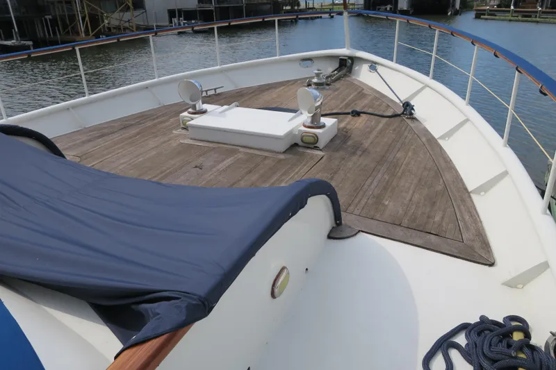Slide: The Image of 1964 Striker Cockpit boat with wooden deck, steps, and mooring rope in marina setting. - 6