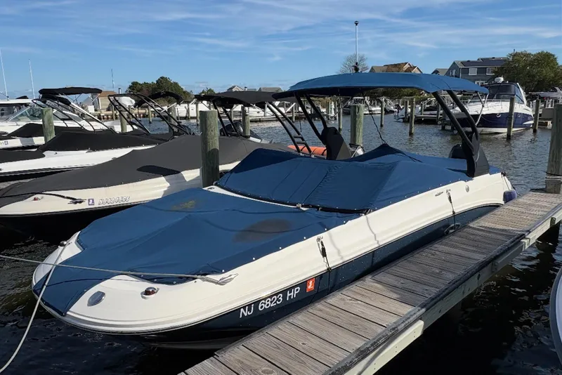 Slide: The Image of 2018 Sea Ray SDX 250 Outboard boat docked at a marina with blue cover. - 1