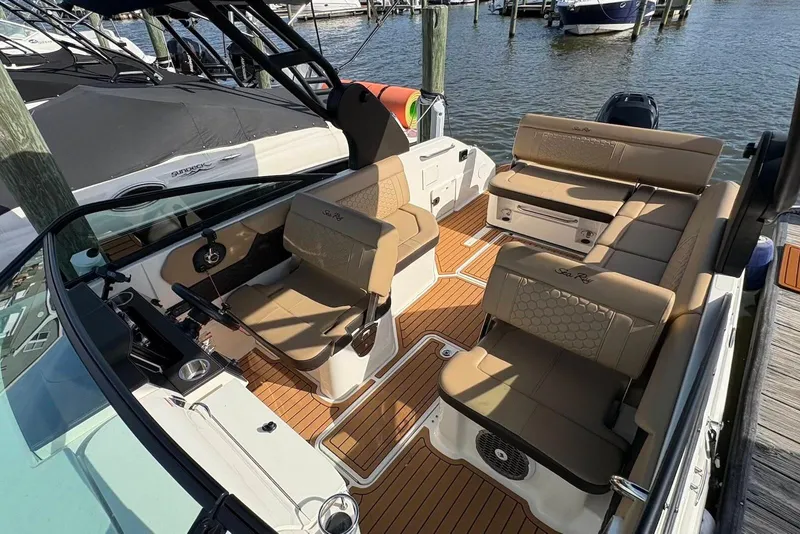 Slide: The Image of 2018 Sea Ray SDX 250 Outboard boat interior with tan seating and wood flooring. - 12