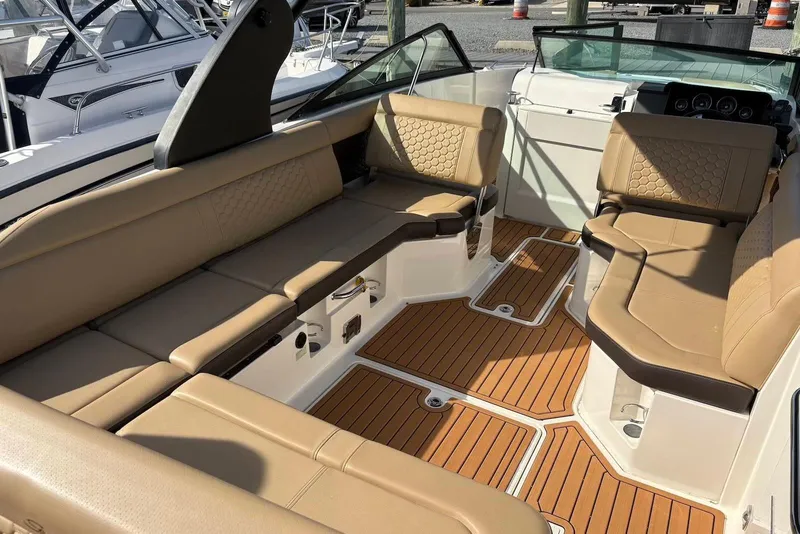 Slide: The Image of 2018 Sea Ray SDX 250 Outboard interior with tan seating and teak-style flooring. - 3