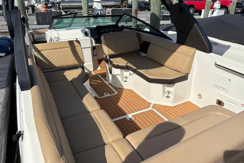 Slide: The Image of 2018 Sea Ray SDX 250 Outboard boat interior with tan seating and wood flooring. - 4