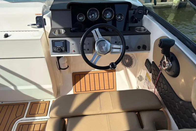 Slide: The Image of 2018 Sea Ray SDX 250 Outboard helm with steering wheel, controls, and seating. - 5