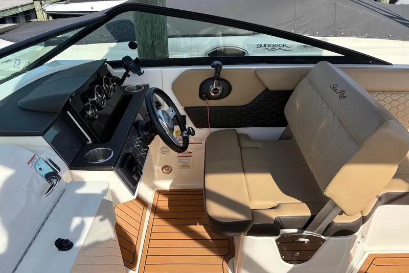 Slide: The Image of 2018 Sea Ray SDX 250 Outboard cockpit with tan seating and modern dashboard. - 6