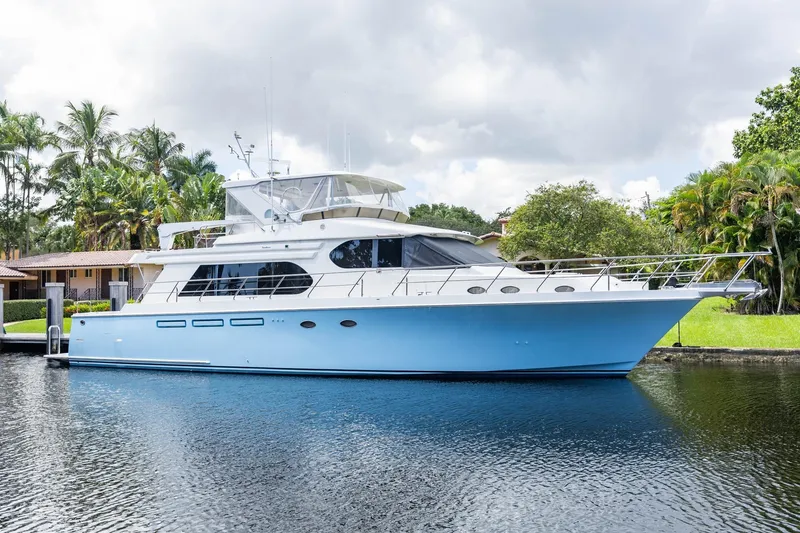 Slide: The Image of 2005 Ocean Alexander Raised Pilothouse Flybridge Sedan yacht docked by lush greenery. - 1