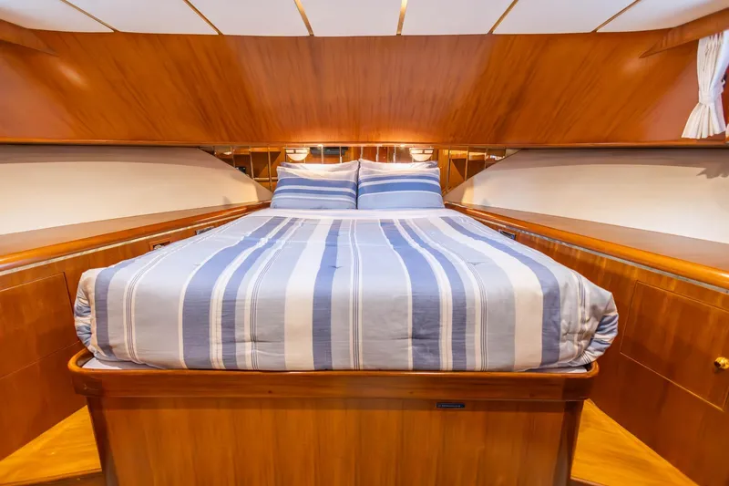 Slide: The Image of Luxurious 2005 Ocean Alexander yacht bedroom with striped bedding and elegant wood finish. - 18