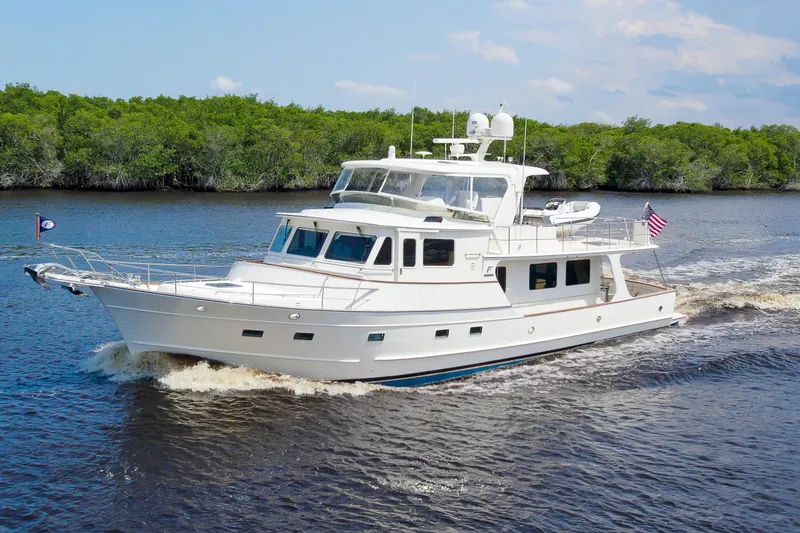 Slide: The Image of Luxurious 2017 Fleming 65 yacht cruising on a serene river with lush greenery. - 1