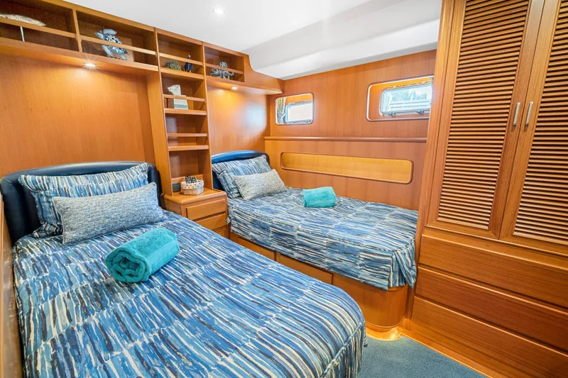 Slide: The Image of Luxurious twin cabin in 2017 Fleming 65 yacht with wooden interiors and blue bedding. - 14