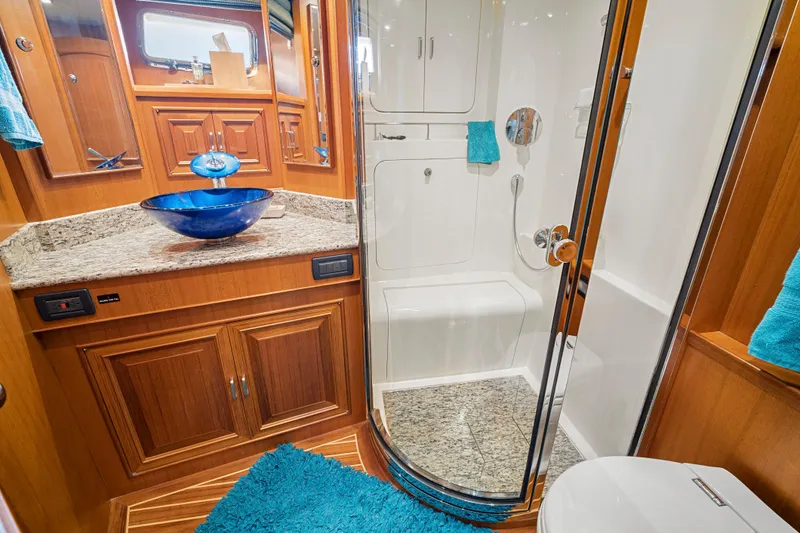 Slide: The Image of Luxurious bathroom in 2017 Fleming 65 yacht with blue accents and wooden cabinetry. - 17