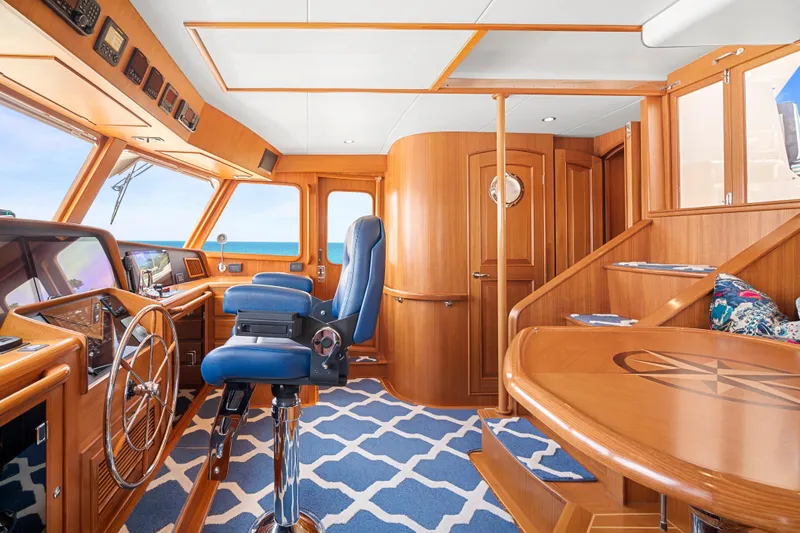 Slide: The Image of Luxurious 2017 Fleming 65 yacht interior with wooden helm, blue seating, and ocean view. - 22