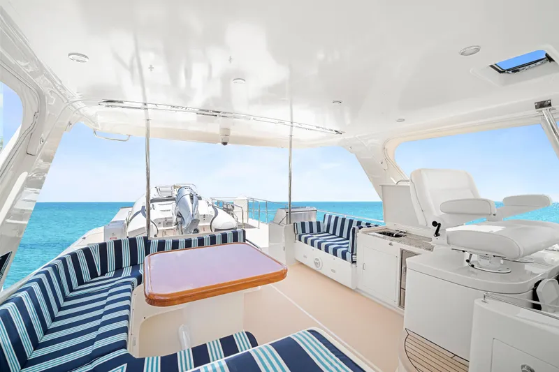 Slide: The Image of Luxurious 2017 Fleming 65 yacht interior with striped seating, ocean view, and helm station. - 26