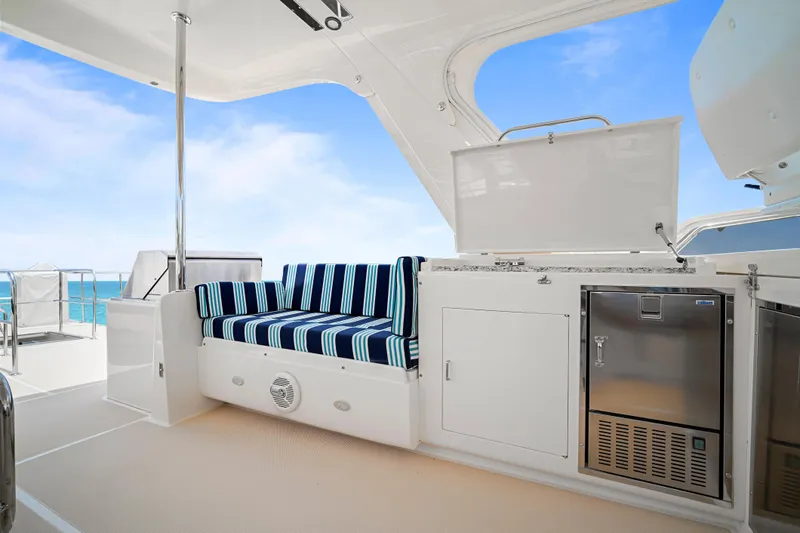 Slide: The Image of Luxurious 2017 Fleming 65 yacht deck with striped seating and stainless steel appliances. - 27