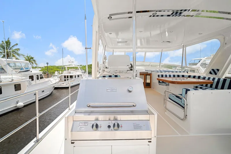 Slide: The Image of Luxurious 2017 Fleming 65 yacht with outdoor seating and grill, docked under a clear blue sky. - 28