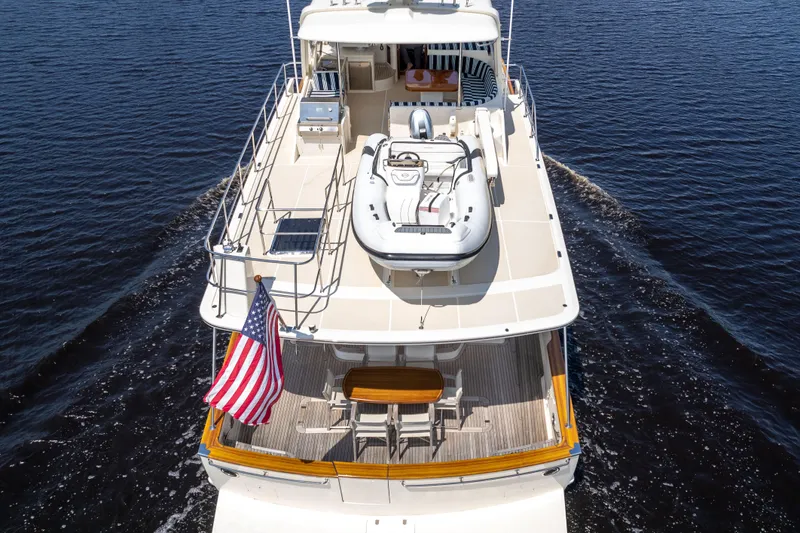 Slide: The Image of Luxury 2017 Fleming 65 yacht cruising on open water, featuring spacious deck and American flag. - 30