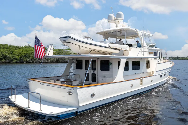 Slide: The Image of Luxurious 2017 Fleming 65 yacht cruising on a serene waterway under a partly cloudy sky. - 31