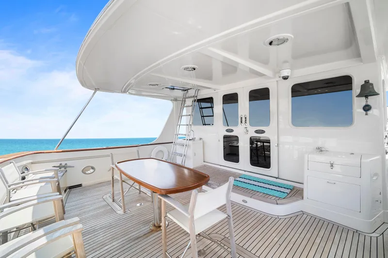 Slide: The Image of Luxurious 2017 Fleming 65 yacht deck with ocean view, featuring elegant seating and dining area. - 32