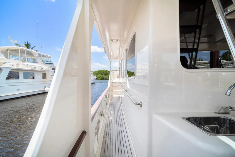 Slide: The Image of Side view of a 2017 Fleming 65 yacht docked, showcasing sleek design and outdoor sink. - 34