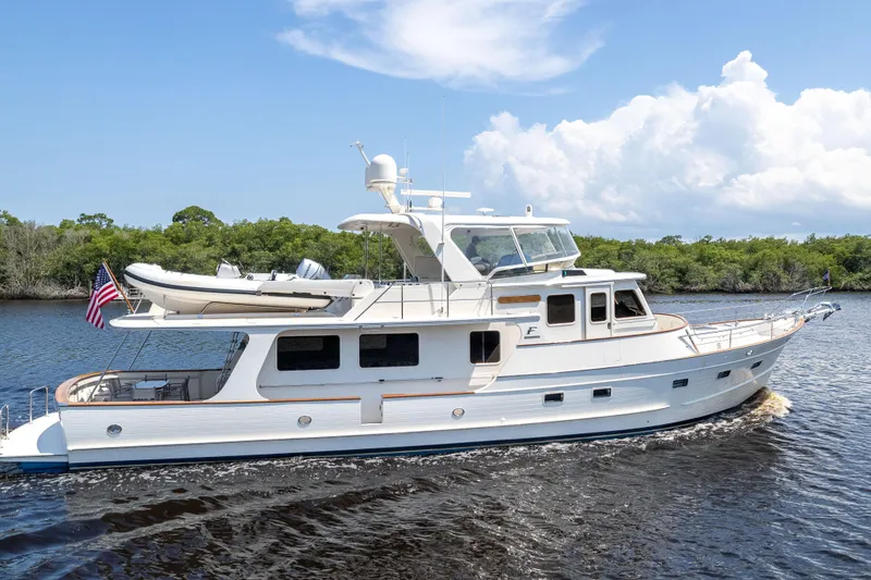 Slide: The Image of 2017 Fleming 65 yacht cruising on a serene waterway under a clear blue sky. - 35