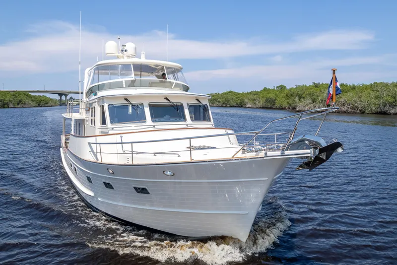 Slide: The Image of 2017 Fleming 65 yacht cruising on a calm river under a clear blue sky. - 46