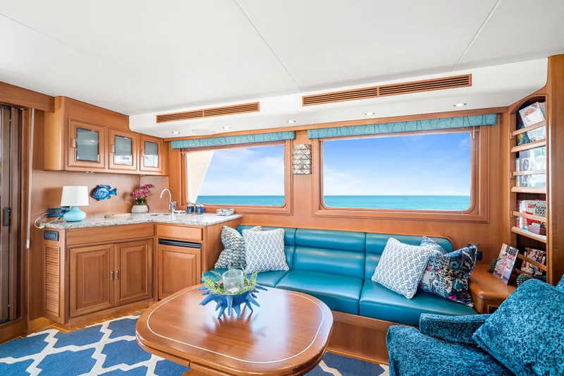 Slide: The Image of Luxurious 2017 Fleming 65 yacht interior with ocean view, featuring elegant wood finishes and plush seating. - 5