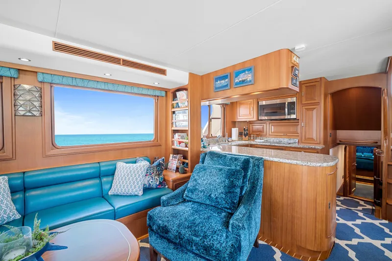 Slide: The Image of Luxurious interior of 2017 Fleming 65 yacht with ocean view, featuring plush seating and modern kitchen. - 6