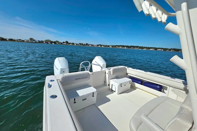 Slide: The Image of 2024 World Cat 325 CC boat on calm water, showcasing spacious deck and dual engines. - 10