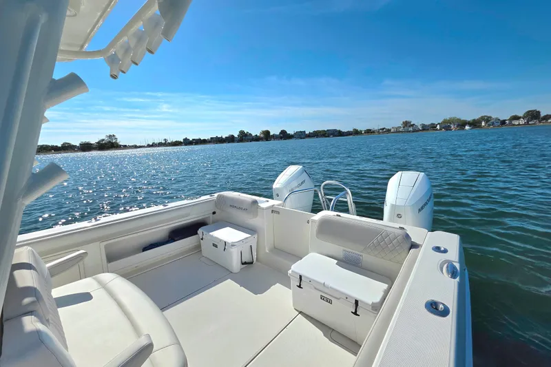 Slide: The Image of 2024 World Cat 325 CC boat interior with twin engines on a sunny day. - 11