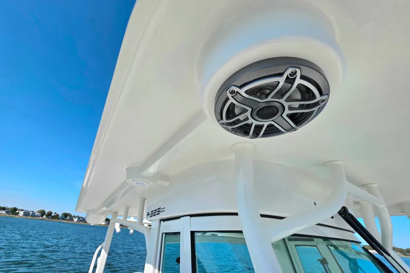 Slide: The Image of 2024 World Cat 325 CC boat with speaker on deck, blue sky background. - 19