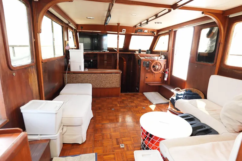 Slide: The Image of Interior of 1982 CHB Classic Trawler 41 with wooden decor and cozy seating area. - 12