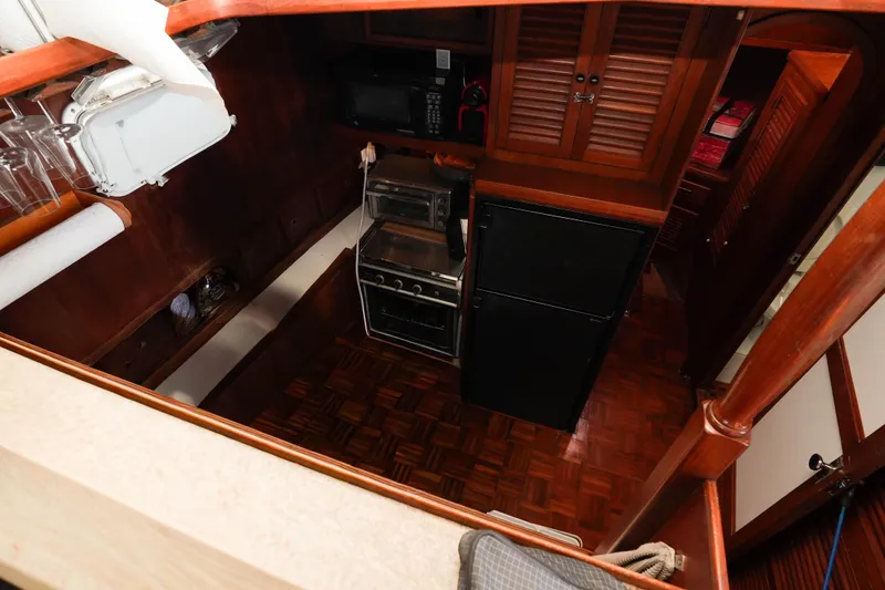 Slide: The Image of 1982 CHB Classic Trawler 41 galley with stove, refrigerator, and wooden cabinetry. - 16